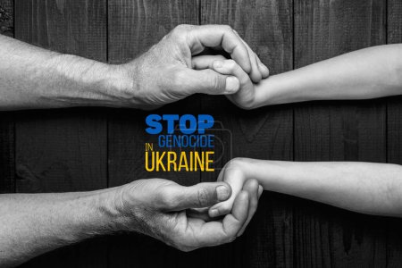 Foto de Manos masculinas sostienen a los niños sobre un fondo oscuro con palabras detener el genocidio en color blanco y negro ucraniano. concepto necesita ayuda y apoyo, la verdad va a ganar - Imagen libre de derechos