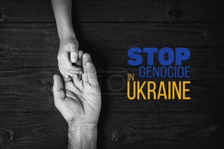 Foto de Manos masculinas sostienen a los niños sobre un fondo oscuro con palabras detener el genocidio en color blanco y negro ucraniano. concepto necesita ayuda y apoyo, la verdad va a ganar - Imagen libre de derechos
