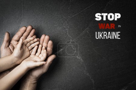 Foto de Manos masculinas sostienen a los niños sobre fondo de mármol oscuro con palabras detener la guerra en Ucrania. concepto necesita ayuda y apoyo, la verdad va a ganar - Imagen libre de derechos