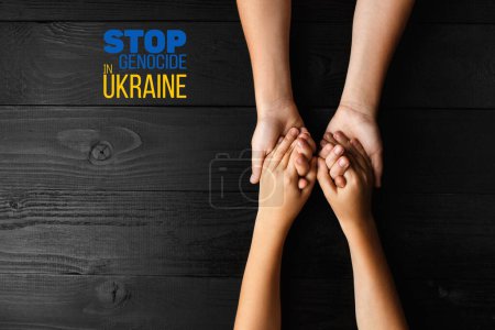 Foto de Niños de las manos abrazándose unos a otros con palabras detener el genocidio en Ucrania. concepto necesita ayuda y apoyo, la verdad va a ganar - Imagen libre de derechos