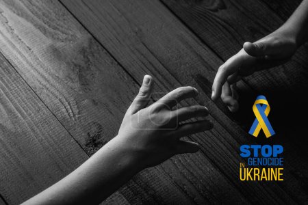 childrens hand reaching out to help the other hand, with words stop genocide in ukraine. black and white color. concept needs help and support, truth will win