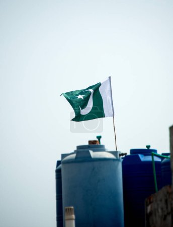 Foto de La bandera nacional de Pakistán ondeando en el cielo azul con nubes, la bandera paquistaní en Nubes fondo cielo azul. - Imagen libre de derechos