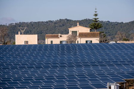 Photo for Buniferri photovoltaic park, small house facing a sea of solar energy plates, Llucmajor, Mallorca, Balearic Islands, Spain - Royalty Free Image
