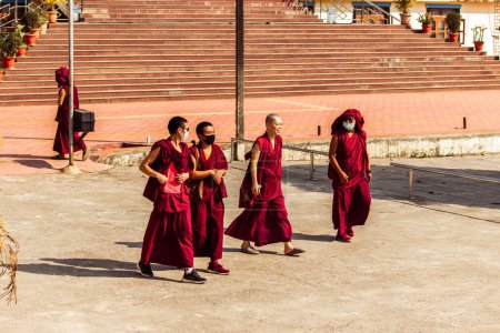 Photo for "Mundgod, Karnataka,India- 6th February 2022: Tibetan monks wearing masks,walking on the street" - Royalty Free Image