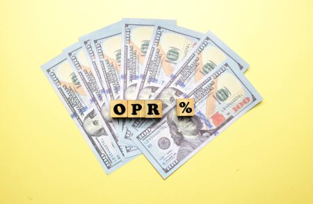 Téléchargez les photos : A picture of OPR % or overnight policy rate on wooden block and fake money. Overnight Policy Rate the interest rate at which a depository institution lends immediately available funds to another depository institution overnight. - en image libre de droit