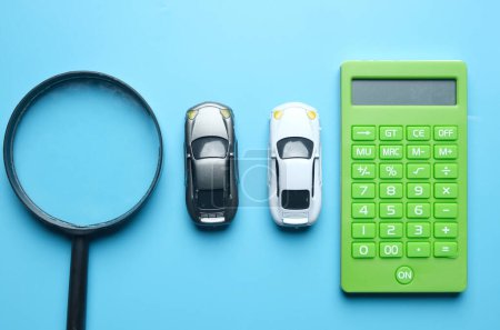 Téléchargez les photos : Flatlay picture of magnifying two cars miniature and calculator. Best deal car to drive. - en image libre de droit