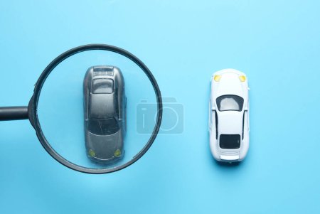 Téléchargez les photos : Selective focus picture of magnifying glass selecting black car with car insigt. Choose your best car to drive. - en image libre de droit