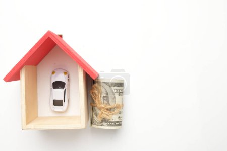 Foto de Imagen plana de la casa en miniatura, dinero falso con visión del coche diorama en el fondo blanco copyspace. - Imagen libre de derechos