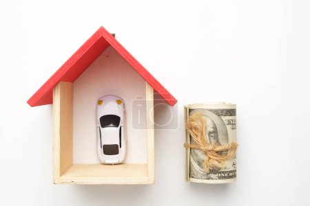 Foto de Flatlay imagen de la casa en miniatura, dinero falso con diorama coche visión sobre fondo blanco. - Imagen libre de derechos