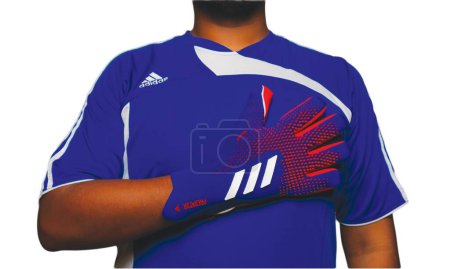 Téléchargez les photos : "Klang, Malaisie 16 juillet 2023 : Photo de mise au point sélective du gant de football Adidas Predator Goalkeeper par un homme sur fond blanc." - en image libre de droit
