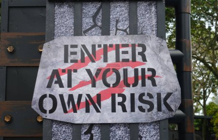 Téléchargez les photos : Une photo d'entrer à vos propres risques signe à l'entrée. - en image libre de droit
