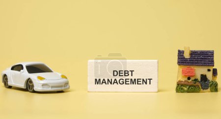 Photo for A picture of car diorama, house miniature with the wooden block written debt management. - Royalty Free Image