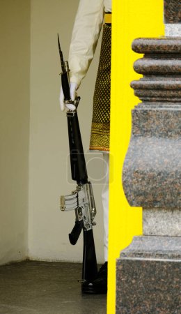 Téléchargez les photos : Une photo de militaires portant un costume malais tenant une baïonnette à la porte. - en image libre de droit