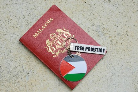 Téléchargez les photos : "Klang, Malaisie 1 novembre 2023 : Une photo de Malaisie Passeport avec drapeau palestinien libre porte-clés sur fond rugueux." - en image libre de droit