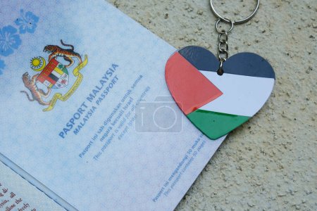 Téléchargez les photos : "Klang, Malaisie- 1er novembre 2023 : Une image rapprochée de la Malaisie Passeport avec le mot ce passeport est valable pour tous les pays sauf Israël et la forme de l'amour Palestine Drapeau porte-clés." - en image libre de droit