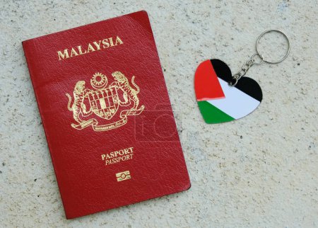 Téléchargez les photos : "Klang, Malaisie- 1 novembre 2023 : Une photo de Malaisie Passeport avec le drapeau palestinien porte-clés sur fond rugueux." - en image libre de droit