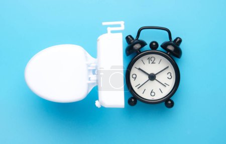 Photo for Flatlay picture of toilet bowl and alarm clock. Toilet break concept. - Royalty Free Image