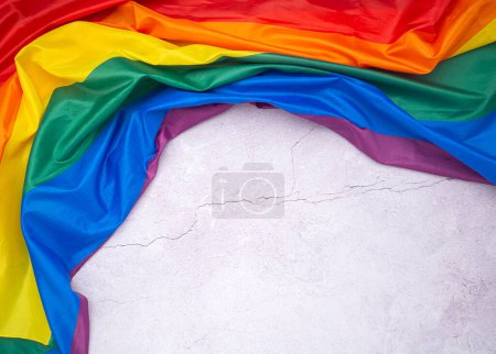 Foto de La bandera del arco iris (LGBT) está en un piso de cemento con espacio para el texto. Vista superior. Acostado. Concepto de amor. - Imagen libre de derechos