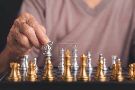 Photo for Senior woman playing chess board game for relaxing. Chessboard game for ideas and competition. Close-up photo. Aged people and relaxation concept. - Royalty Free Image