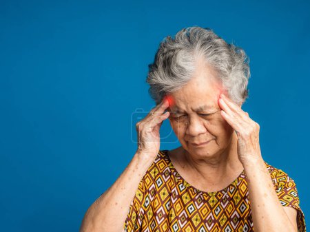 An elderly Asian woman who has a severe headache suffers from a stroke, brain attack, or migraines. Brain diseases problem cause chronic severe headaches. Aged people and healthcare concept.
