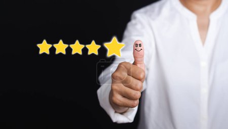 Photo for Best excellent services for satisfaction client giving a five-star rating. Customer feedback, service evaluation, experience, and satisfaction conceptual. Hand with thumb up for smiley face icon. - Royalty Free Image