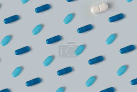 Foto de Patrón de pastillas sobre un fondo azul. Muchas píldoras sobre un fondo claro. - Imagen libre de derechos