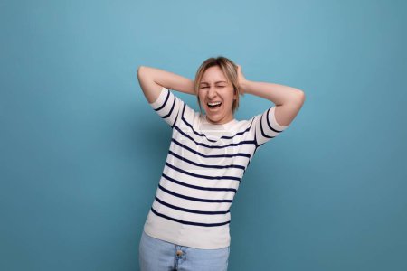 Téléchargez les photos : Photo rapprochée de l'adorable femme millénaire blonde heureuse énergique riant à haute voix sur fond bleu avec espace de copie. - en image libre de droit