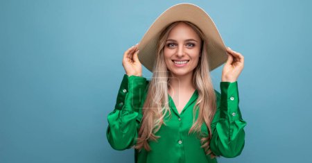 Téléchargez les photos : Élégant jeune femme en chapeau d'été avec bord sur fond bleu. - en image libre de droit