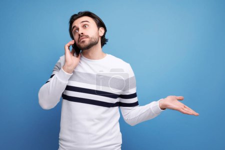 Téléchargez les photos : Beau caucasien brunette jeune homme bavarder au téléphone. - en image libre de droit