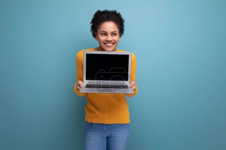 Téléchargez les photos : Confiant intelligent jeune femme d'affaires hispanique de 25 ans avec afro avec un ordinateur portable dans ses mains. - en image libre de droit