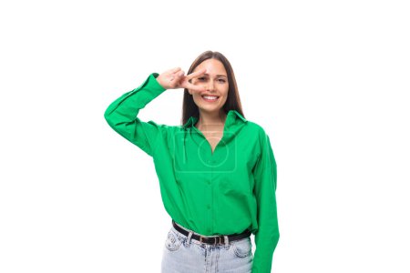 Téléchargez les photos : Brune aux yeux bruns jeune femme d'affaires dans une chemise verte sur un fond blanc avec espace de copie. - en image libre de droit