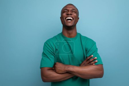 Téléchargez les photos : Jeune modeste américain gars habillé dans un t-shirt de base sur le fond avec espace de copie. - en image libre de droit