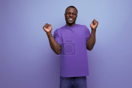 Téléchargez les photos : Jeune Américain habillé dans un t-shirt de base avec ses mains levées pour comprendre sur le fond avec l'espace de copie. - en image libre de droit