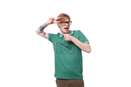Photo for Portrait of a young smart red-haired guy in a green t-shirt having critical thinking. - Royalty Free Image