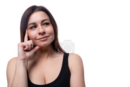 Photo for A 25-year-old woman with black hair thoughtfully holds her head with her hand. - Royalty Free Image