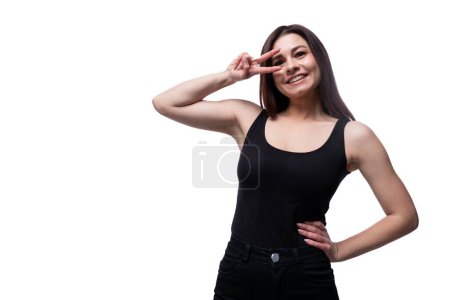 Photo for Young stylish woman with black hair wearing a black off-shoulder T-shirt on a white background. - Royalty Free Image
