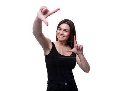 Photo for Young slim brunette woman wearing a tight T-shirt on a white background. - Royalty Free Image