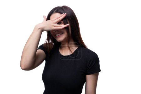 Photo for 25 year old cute woman with straight black hair hides her face with her hands. - Royalty Free Image