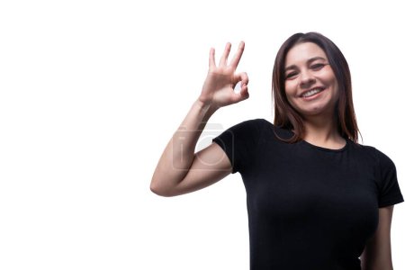 Photo for Caucasian cute young woman with black hair dressed in a black t-shirt gesturing on a white background with copy space. - Royalty Free Image