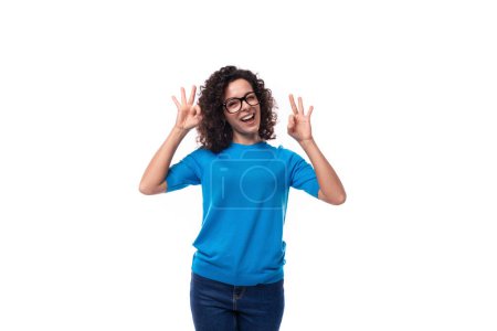 Foto de Seguro de éxito joven mujer caucásica con rizos vestidos con una camiseta azul. - Imagen libre de derechos