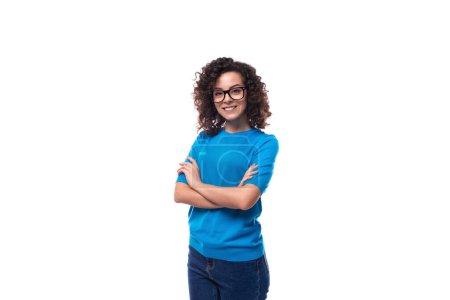 Téléchargez les photos : Confiant succès jeune femme caucasienne avec des boucles habillé dans un t-shirt bleu. - en image libre de droit