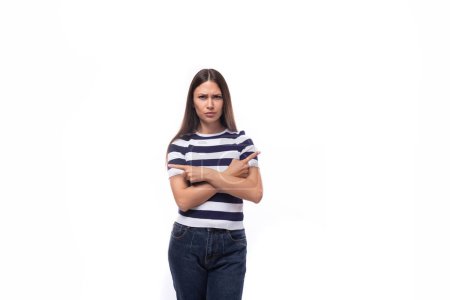 Téléchargez les photos : Bouleversé mince jeune femme brune en noir et blanc t-shirt rayé sur fond blanc avec espace de copie. - en image libre de droit