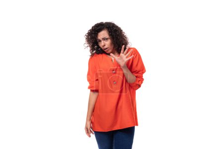 Téléchargez les photos : Jeune femme d'affaires caucasienne avec une coiffure bouclée habillée d'un chemisier orange montre son désaccord. - en image libre de droit