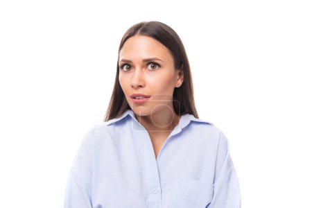 Téléchargez les photos : Portrait en gros plan charmante jeune femme brune européenne vêtue d'une chemise bleu ciel sur fond isolé avec espace de copie. - en image libre de droit