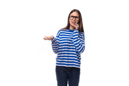 Foto de Joven esbelta mujer con el pelo liso usa gafas y habla por teléfono. - Imagen libre de derechos
