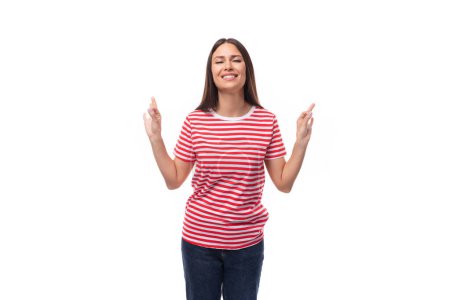 Téléchargez les photos : Jeune femme brune européenne calme vêtue d'un t-shirt rayé montre que tout est super sur un fond blanc. - en image libre de droit