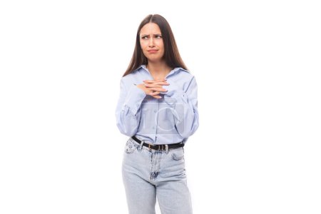 Téléchargez les photos : Charmante jeune femme brune européenne vêtue d'une chemise bleue et d'un jean sur fond isolé avec espace de copie. - en image libre de droit