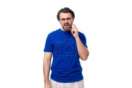 Téléchargez les photos : Jeune homme brune caucasien brutal avec coiffure élégante et barbe en t-shirt bleu avec maquette d'identité. - en image libre de droit