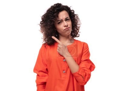 Téléchargez les photos : Jeune élégant bouclé caucasien brunette femme habillé en chemisier orange. - en image libre de droit