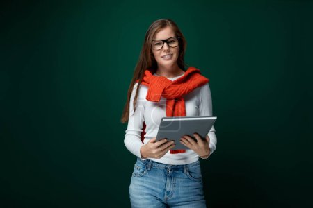 Photo for Cute young woman in glasses holding tablet, business concept. - Royalty Free Image